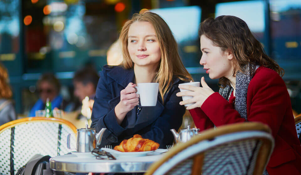 Zwei Frauen trinken ein warmes Getränk in einem Café Zwei Frauen trinken ein warmes Getränk in einem Café